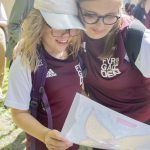 En ungdom och ett barn som håller om varandra och tittar på ett deplom.